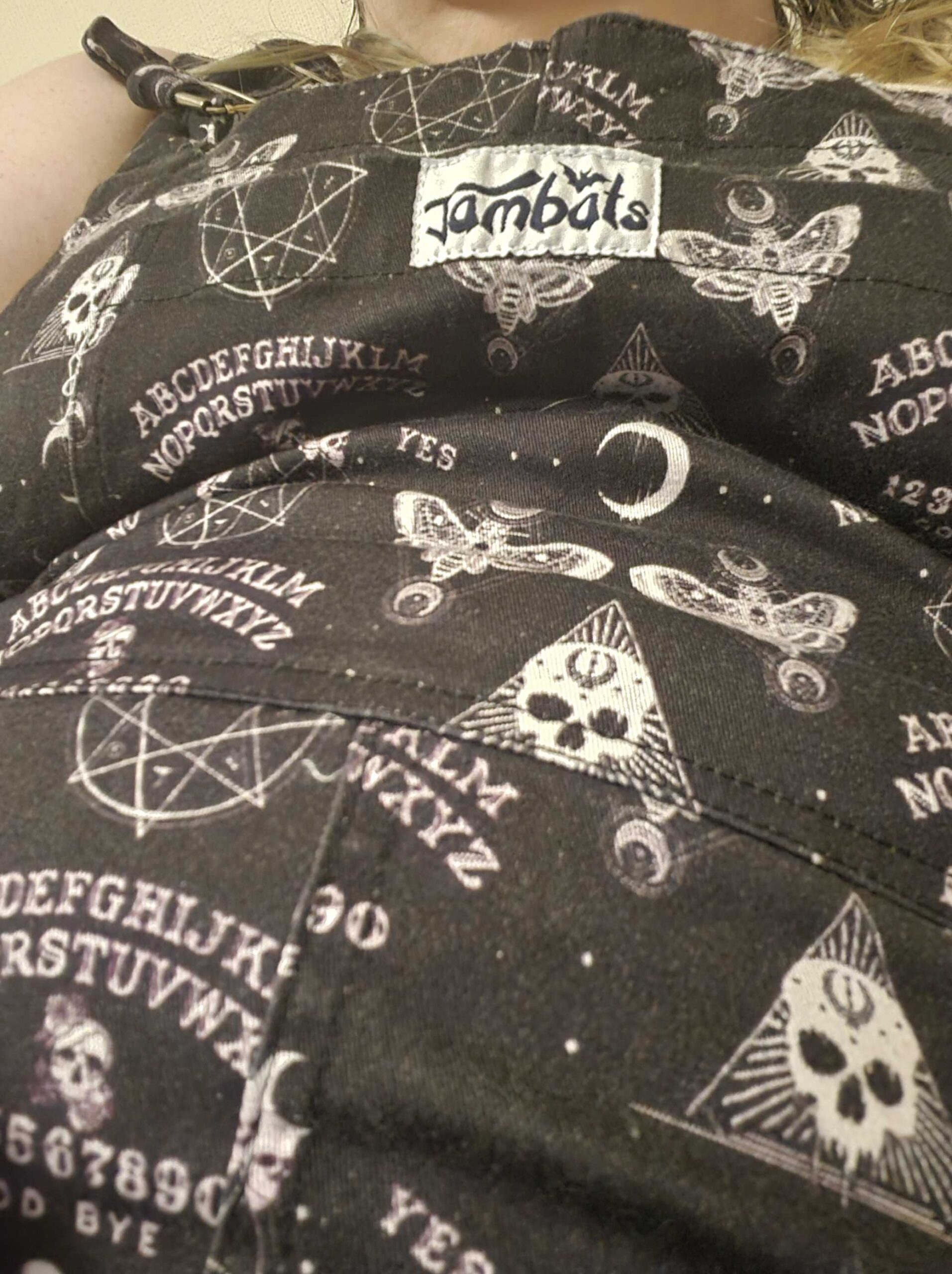 Dungarees with occult images on, skulls, ouija boards, etc.